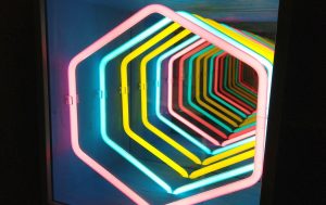 Fotografia colori, opera arte contemporanea Paolo Scirpa, scatola con tubi al neon rosa, giallo, blu e specchi
