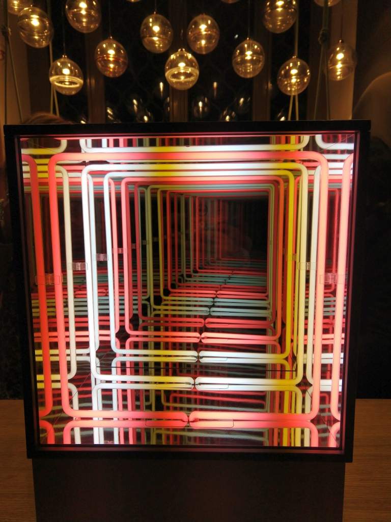 Fotografia colori, opera arte contemporanea Paolo Scirpa, scatola con tubi al neon rosa, bianco e specchi