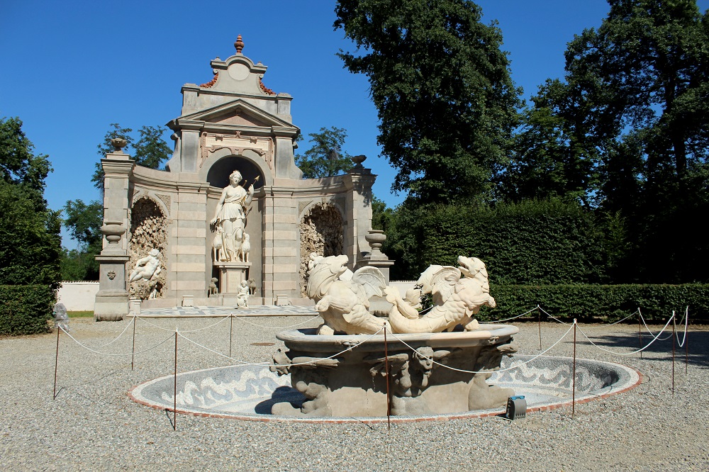 vista laterale del teatro di diana con in primo piano la fintana e dietro il teatro con la statua