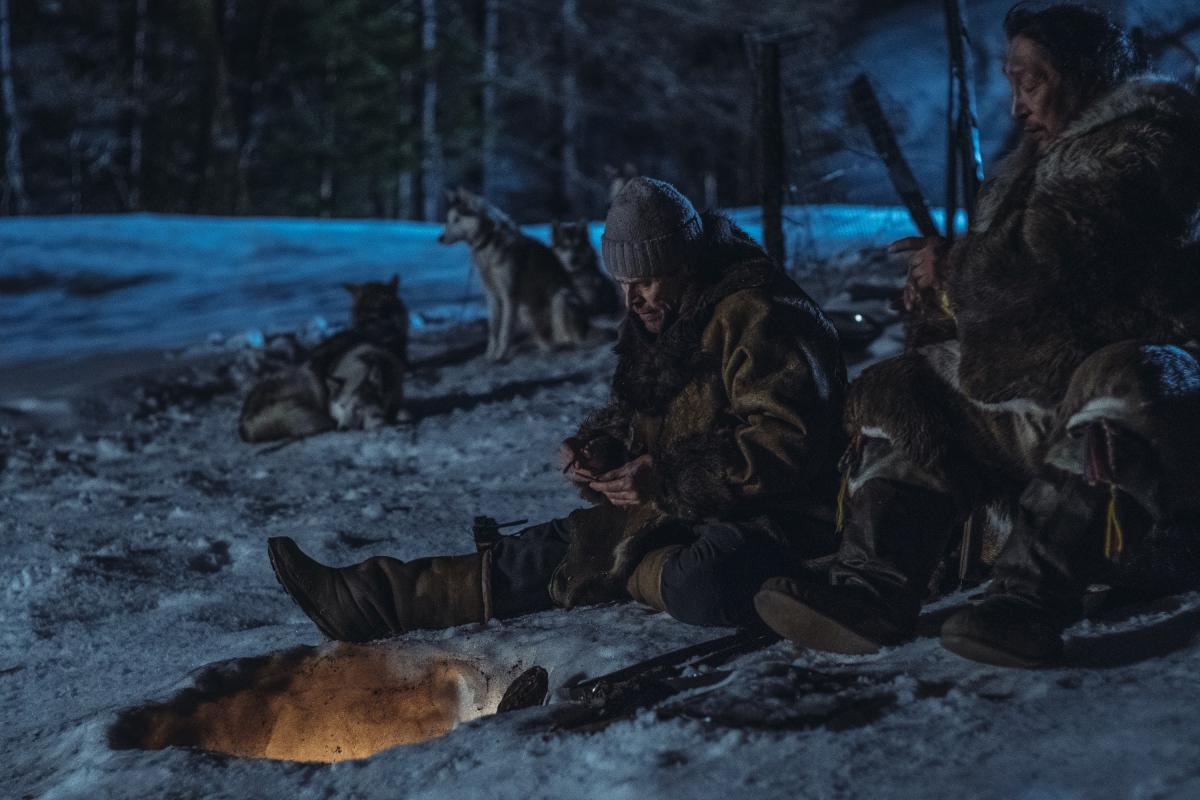 una scena del film Siberia di Abel Ferrara, gli attori sono in un bosco seduti per terra sunna neve