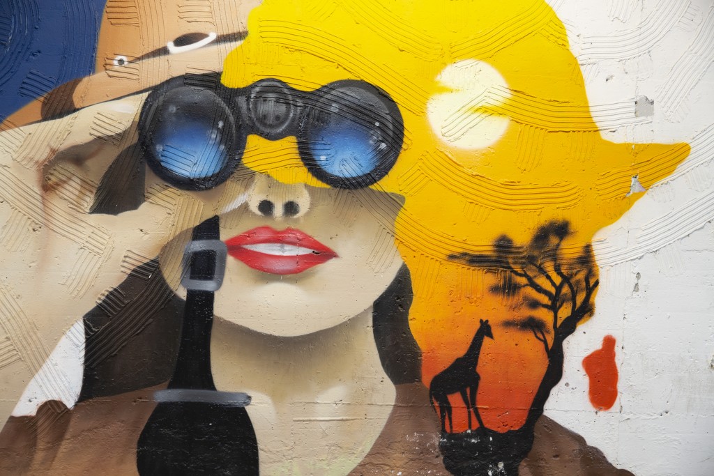MuseoCity 2020, fotografia, colori, street art, primo piano volto donna che guarda con binocolo