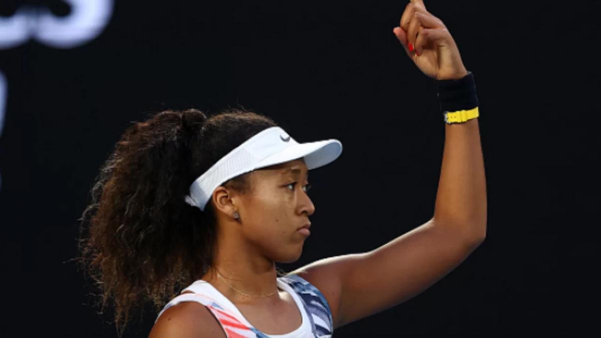 immagine di profilo della tennista Naomi Osaka con un braccio alzato