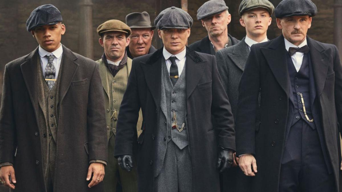 Immagine della serie tv Peaky Blinders dove alcuni uomini con il berretto camminano verso la telecamera