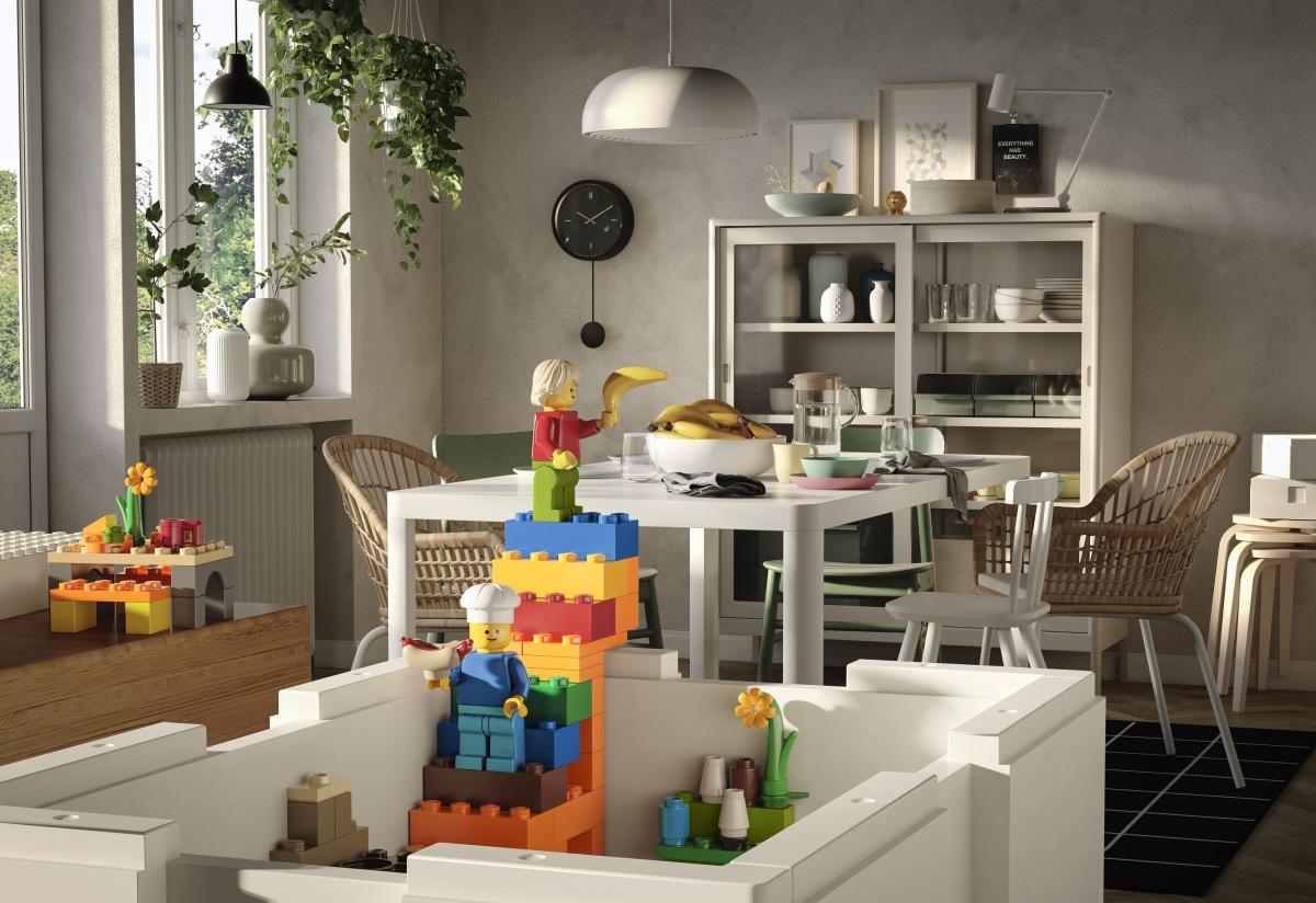 in primo piano una scatola IKEA LEGo BYGGLEK sullo sfondo una sala da pranzo con tavolo e dispensa