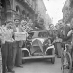 la milano bombardata Vincenzo Carrese ritratto sul tetto di un'automobile a Milano