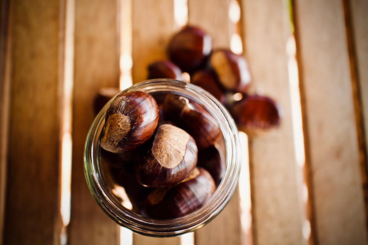 Mal d'autunno vitamine cachi castagne, un barattolo di castagne visto dall'alto su un tavolo di legno