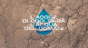 Frase "L'acqua di oggi sarà l'acqua del domani" con goccia d'acqua disegnata su sfondo rappresentante terreno arido