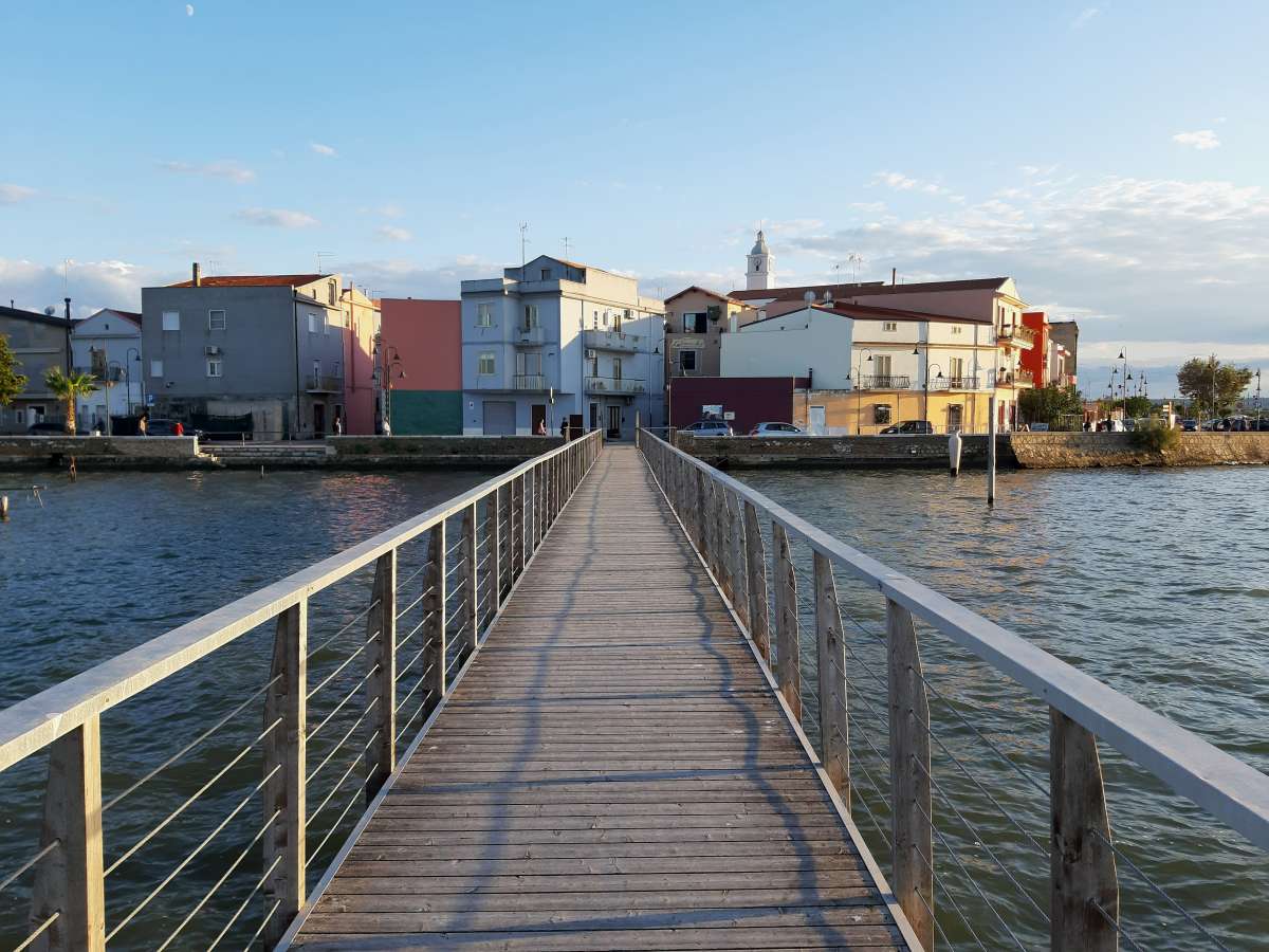 I migliori laghi italiani: scorcio del borgo di Lesina dal pontile che attraversa il Lago di Lesina e Varano