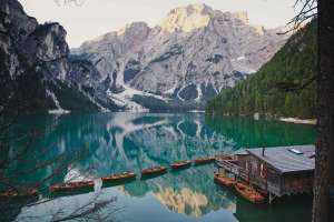 I migliori laghi italiani: immagine panoramica del lago di Braies, con le dolomiti innevate sullo sfondo e riflesse nelle acque verde smeraldo