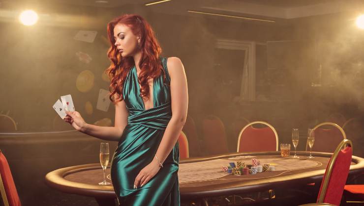 attractive-redheaded-girl-long-blue-satin-dress-is-posing-with-two-aces-her-hand-against-poker-table-luxury-casino-passion-cards-chips-alcohol-win-gambling-it-is-as-female-enterta - fonte_Freepik.com